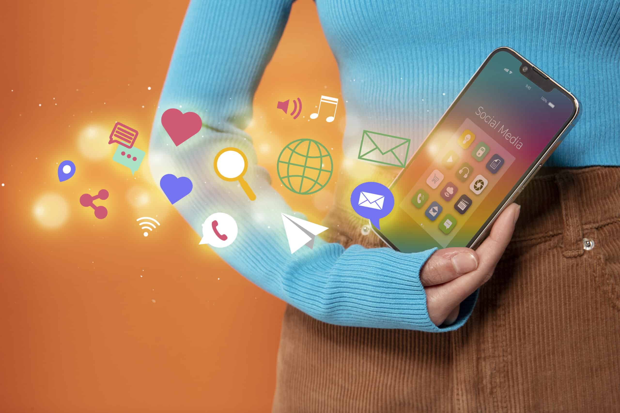 Pessoa segurando smartphone com ícones digitais representando redes sociais, ilustrando estratégias de conteúdo de marketing online.