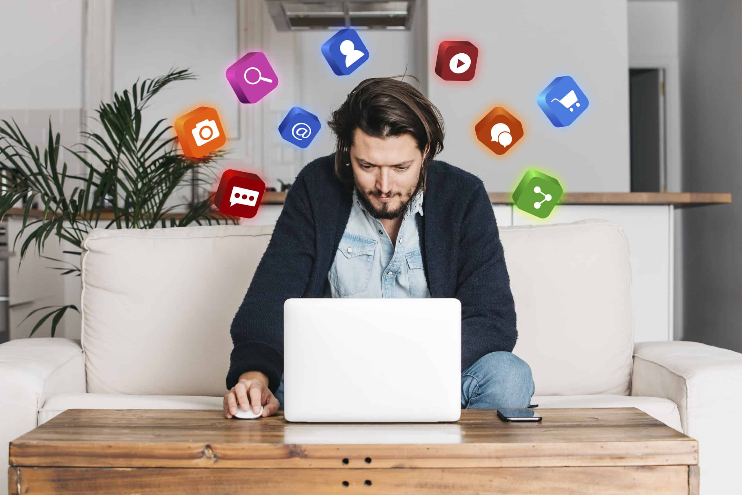 Homem trabalhando em um laptop, cercado por ícones coloridos de redes sociais, representando o uso de plataformas digitais para desenvolver estratégias eficazes de marketing digital e engajamento online.
